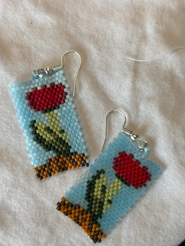 Pair of beaded earrings with floral design on a light background