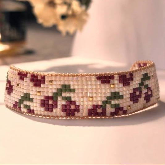 Beaded headband with floral pattern on a white surface