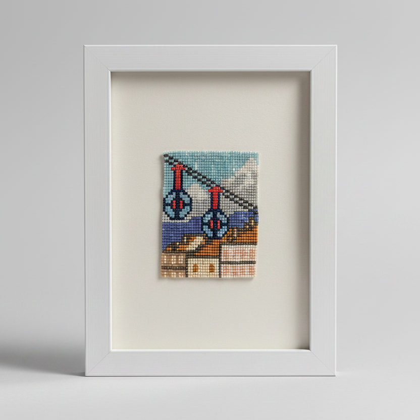 Framed cross-stitched artwork of a bicycle on a white background