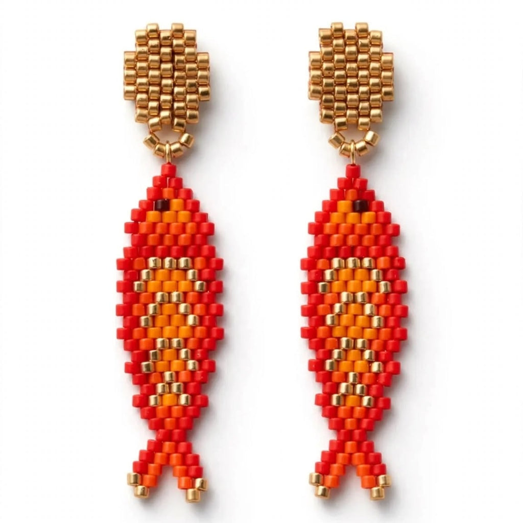 A pair of handmade beaded fish drop earrings featuring red, orange, and gold seed beads on a plain white background.