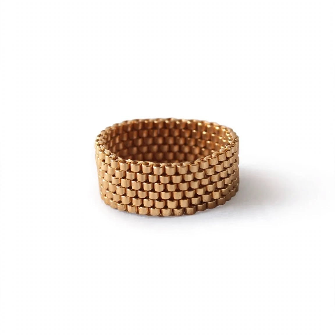 A wide, textured gold mesh band ring, photographed on a clean white background.
