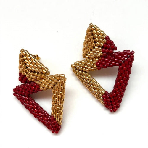 A pair of handmade geometric beaded earrings featuring alternating triangular sections of metallic gold and deep red seed beads, displayed on a clean white background.