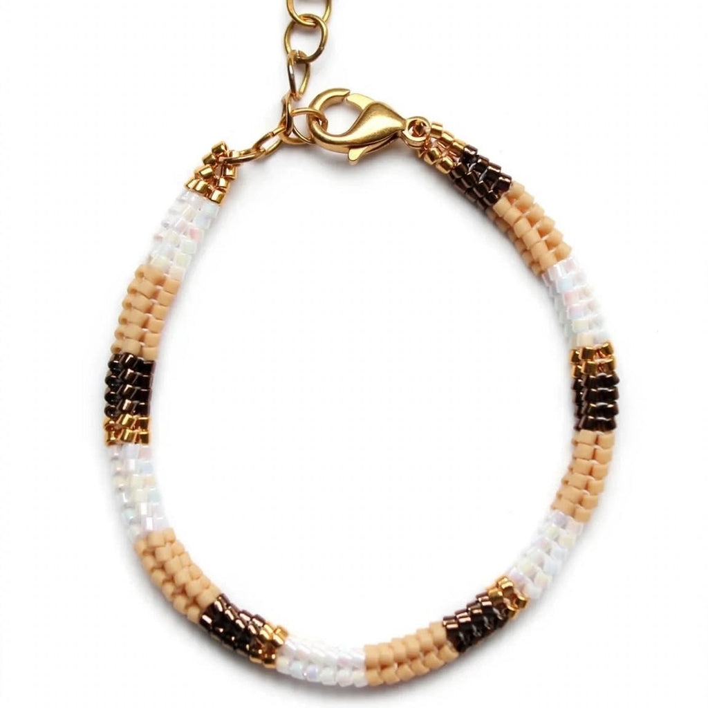 A beaded bracelet with alternating sections of white, light beige, and dark brown seed beads, finished with a gold-tone lobster clasp and extension chain, shown on a plain white background.