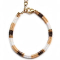 A beaded bracelet with alternating sections of white, light beige, and dark brown seed beads, finished with a gold-tone lobster clasp and extension chain, shown on a plain white background.