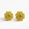 A pair of handmade beaded stud earrings with a geometric pattern of yellow and light blue beads, displayed on a clean white background.