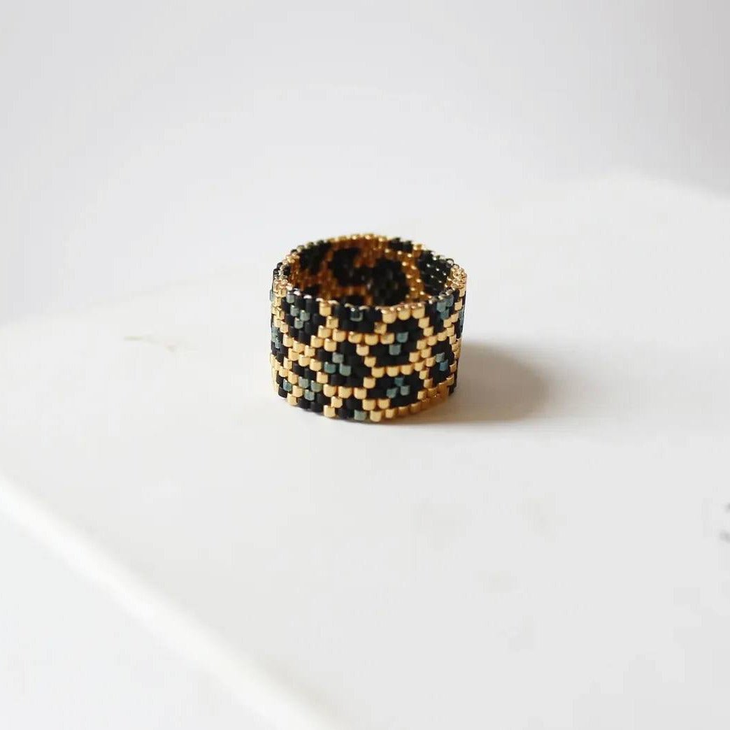 Beaded ring with a geometric pattern on a white surface