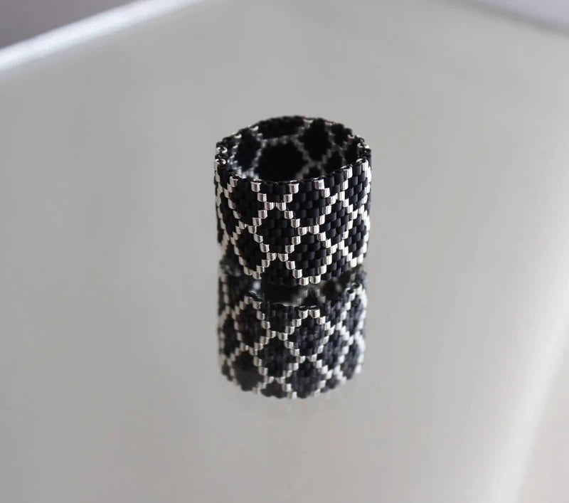 Black and white patterned cylindrical object on a light gray background