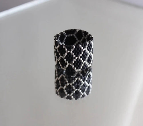 Black and white patterned cylindrical object on a light gray background