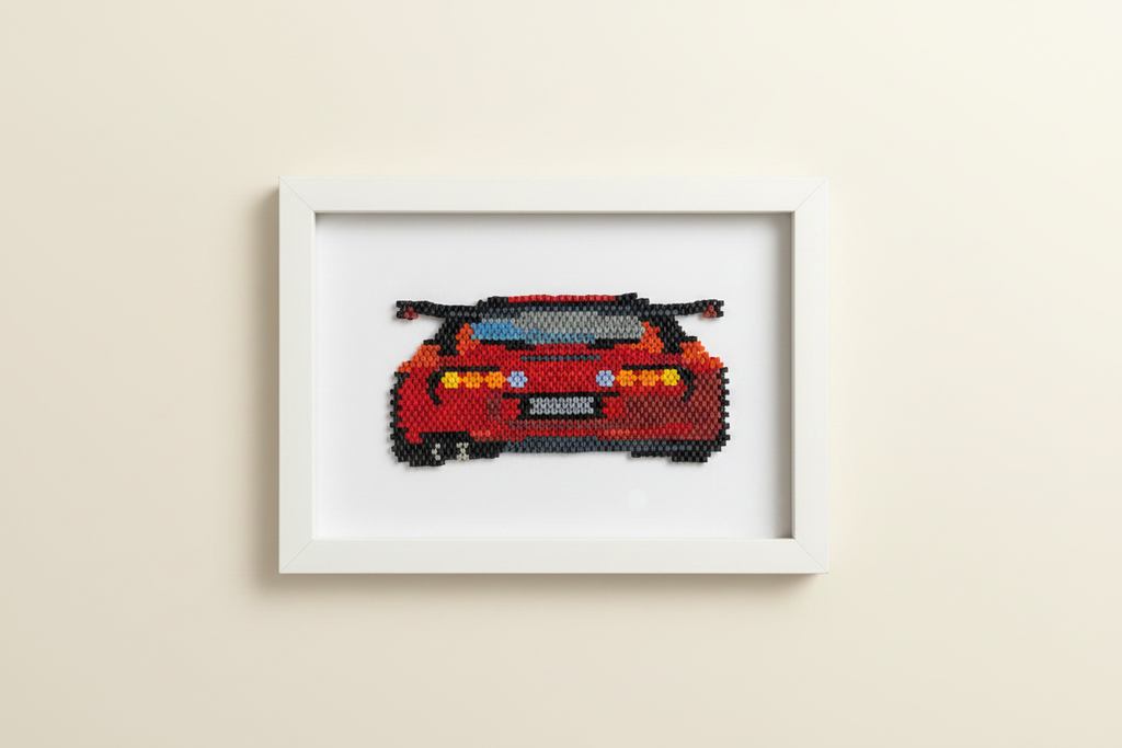Framed cross-stitched red car on a beige wall