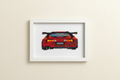 Framed cross-stitched red car on a beige wall